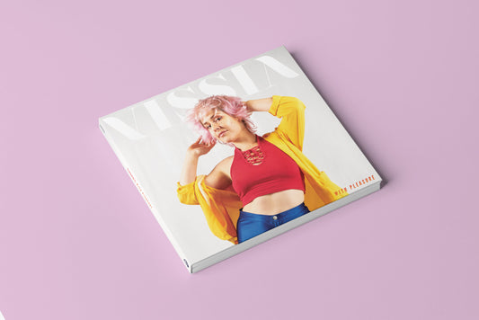 VISSIA With Pleasure digipack CD; the cover is a medium shot photo of a pink-haired woman on a white background; she is wearing silver hoop earrings, shiny blue disco pants, a fuschia halter top, and bright yellow light blazer