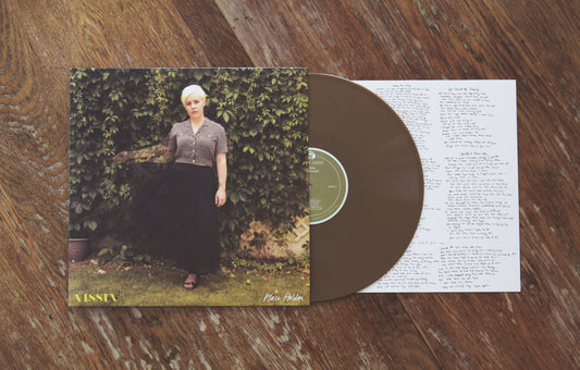 VISSIA Place Holder Limited Edition gold vinyl; the cover shows a short haired blonde woman in long black skirt and grey button-up shirt posing against a wall of green vines